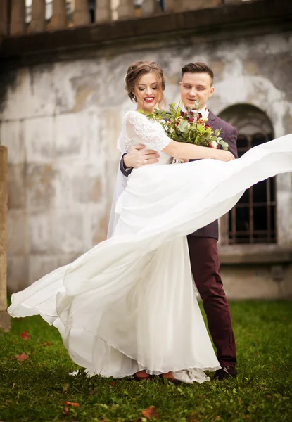 Elegante bruid en bruidegom poseren samen buitenshuis op een bruiloft da — Stockfoto