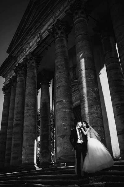 Feliz pareja de boda de lujo está de pie y besándose en el stree — Foto de Stock