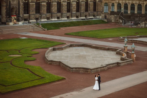 Pareja de boda está de pie y besándose en las calles de la ciudad vieja — Foto de Stock