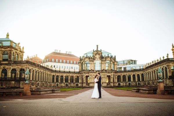 Pareja de boda está de pie y besándose en las calles de la ciudad vieja — Foto de Stock