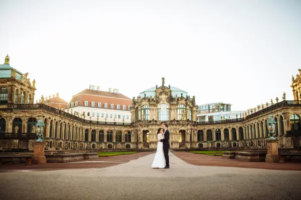 Feliz pareja de boda de lujo está de pie y besándose en las calles de la ciudad vieja — Foto de Stock