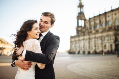 Muhteşem bir düğün çifti, eski şehirde mimari ile güneşli bir günün tadını çıkarıyor. 