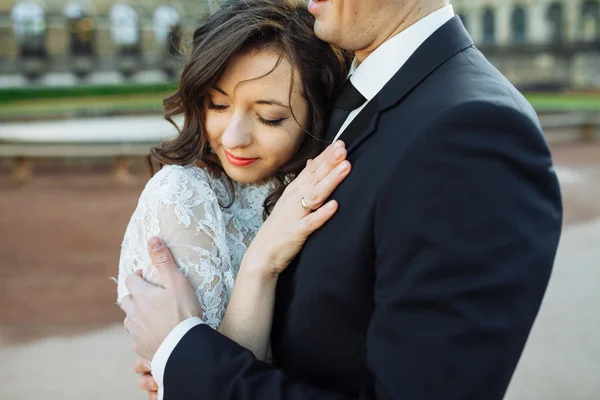 Beau couple de mariage heureux s'embrasse en plein air à fond de rue de la ville . — Photo