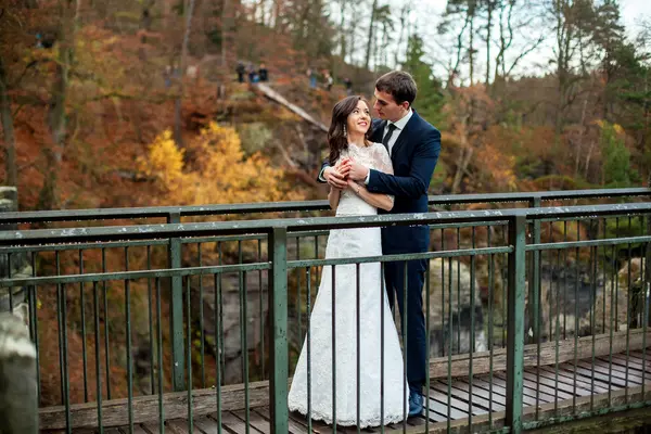 Couple de mariage posant dans le contexte de la montagne. Mariée agitant les cheveux — Photo