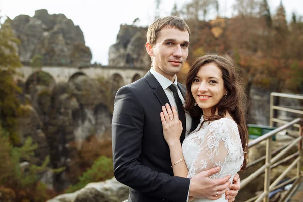 Bröllop par stående i bergen mot himlen. Söta romantiska ögonblick. Bästa dagen i livet för bruden. — Stockfoto