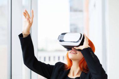 Sanal gerçeklikteki kadın ofisteki çalışma yerinde havayı işaret ediyor.