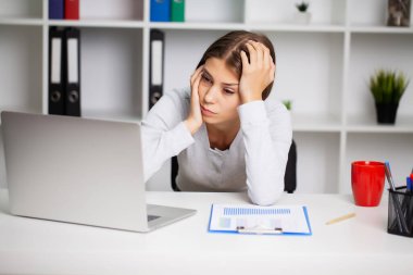 Şiddetli diş ağrısı çeken bir kadın elini yanağının üzerinde tutuyor.