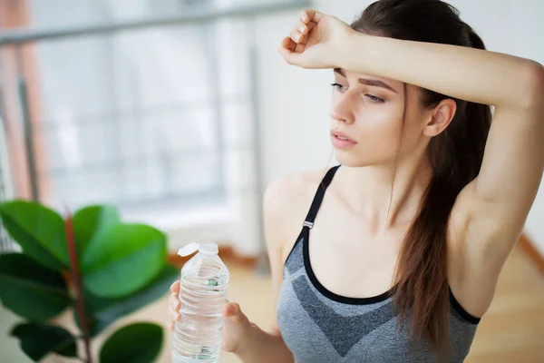 Женщина пьет воду в спортзале после тренировки — стоковое фото
