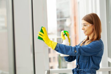 Ofisinde temizlik malzemeleri olan üniformalı güzel bir kadın.
