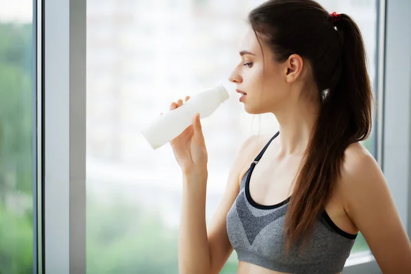 Joven hermosa mujer bebiendo de botella de plástico de yogur — Foto de Stock