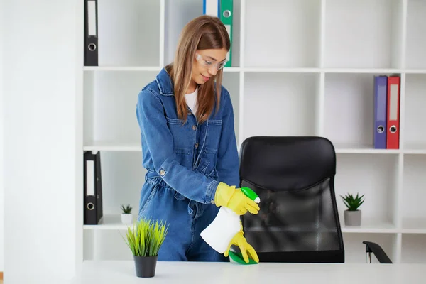 Ładna kobieta w mundurze z zaopatrzeniem sprzątającym w biurze — Zdjęcie stockowe