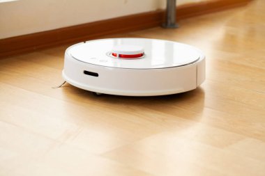 Robot elektrikli süpürge daireyi belli bir zamanda otomatik olarak temizliyor. Akıllı ev.