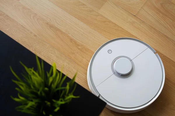 Робот-пылесос выполняет автоматическую уборку квартиры в определенное время. Умный дом. — стоковое фото