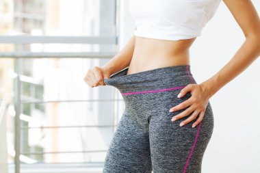 Diyet konsepti, büyük pantolonla diyet yapan zayıf kız.