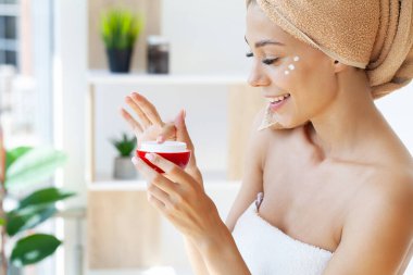 Güzel bir kadın Asya cilt bakım ürünü kullanıyor, nemlendirici.