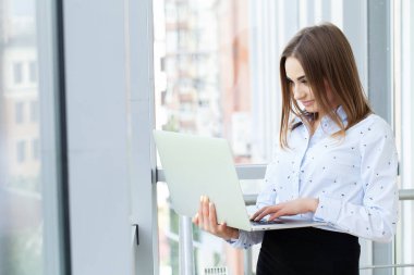 İş yerinde dizüstü bilgisayarla çalışan çekici bir iş kadını..