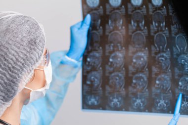 Güzel kadın radyoloji uzmanı MRI görüntülerine bakıyor.