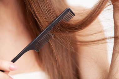 Soyunma odasında elinde tarak olan kadın..