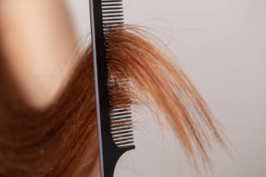 Soyunma odasında elinde tarak olan kadın..