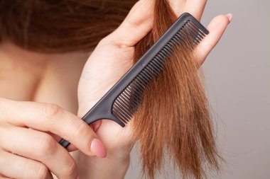 Soyunma odasında elinde tarak olan kadın..