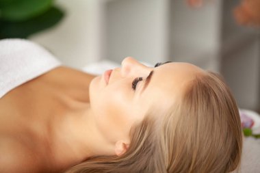 Yüz masajı, kaplıca tedavisi gören genç bir kadının yakın çekimi..