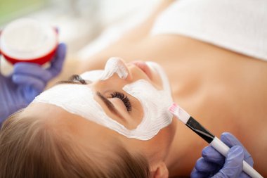 Yüzünde kilden bir maske olan çekici, komik bir kadın..