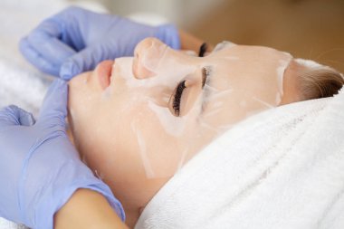 Kaplıca, yüzünde kumaş maske olan çekici, komik kadınlar..