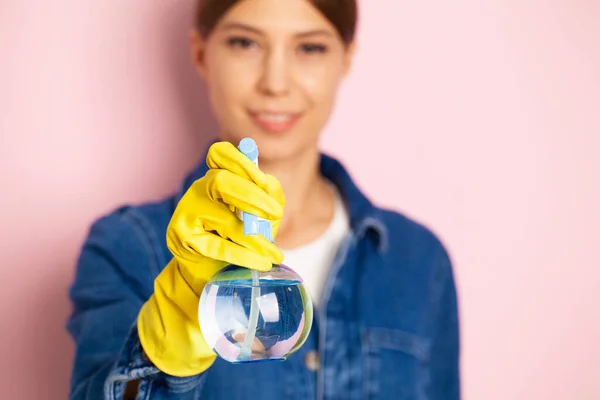 Cleaning company worker in overalls, yellow gloves and cleaning supplies