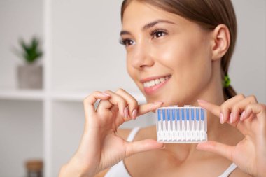 Kadın dişleri temizlemek için fırça kullanıyor.