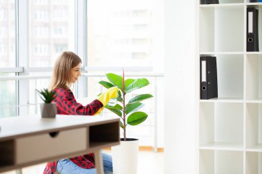 Ofisinde temizlik malzemeleri olan üniformalı güzel bir kadın.