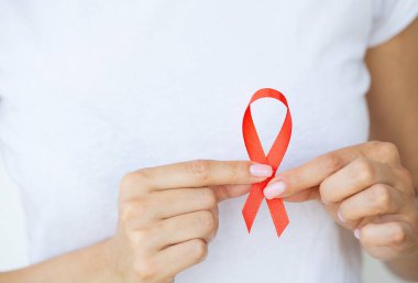 HIV 'li kırmızı kurdele tutan kadın, AIDS Günü Farkındalık Kurdelesi.