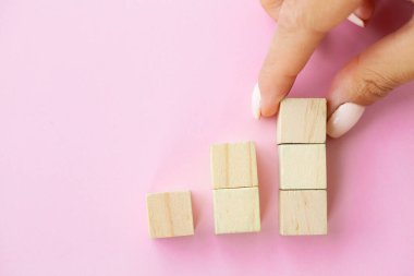 Kadın eli boş tahta küpleri girdi ifadeleri ve bilgi simgesi için kopyalama alanı ile birlikte masaya yerleştiriyor ve istifliyor.