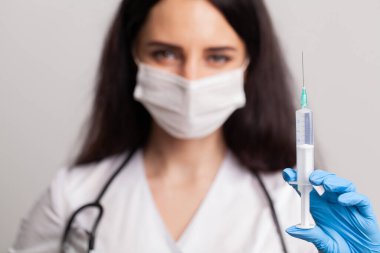 Uzamış elinde kameraya doğru uzanan şırıngayı tutan kadın..