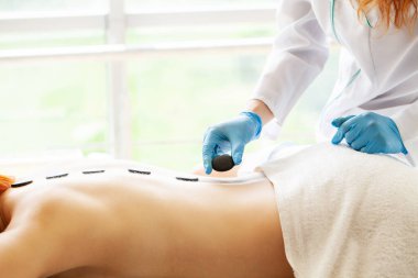 Güzel bir kadın sıcak taş masajını kaplıyor Güzellik tedavileri