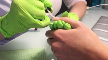 Güzellik stüdyosunda manikürcünün yeni manikür yapmasına yakın çekim.