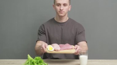Bir adam uygun beslenme için yüksek protein içerikli yiyecekler bulundurur.