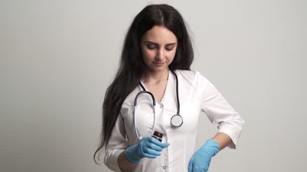 Kobieta-lekarz trzymający butelkę tabletek — Wideo stockowe