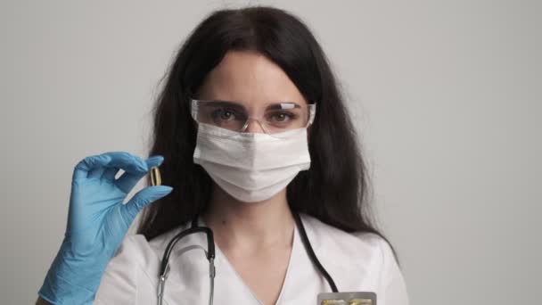 Fiatal nő orvos kezében egy tabletta vitaminok — Stock videók