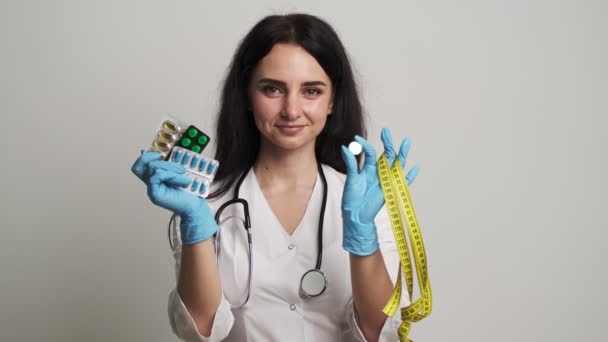 Kvinna läkare i vit rock håller effektiv viktminskning piller — Stockvideo