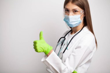 Genç doktor eldivenlerde iyinin sembolünü gösteriyor.