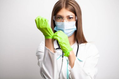 Klinikteki doktor koruyucu eldivenleri değiştiriyor.