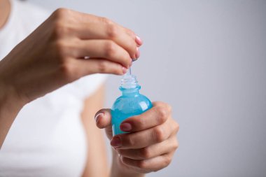 Ellerinde nemlendirici krem tutan güzel genç bir kadın.