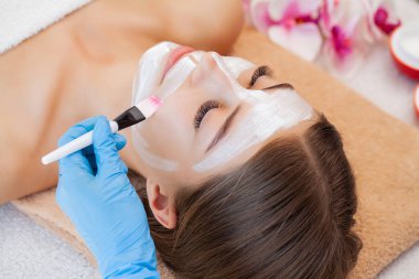 Kaplıca salonundaki kadın yüzüne besleyici maske takıyorum.