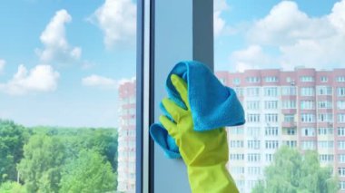 Pencereleri süngerle temizleyen genç bir kadın.