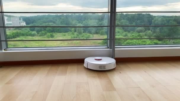 Robot stofzuiger voert automatische reiniging van het appartement op een bepaald moment. — Stockvideo