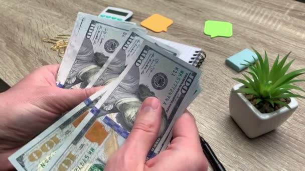 Человек считает банкноту в 100 долларов, полученную по студенческому кредиту — стоковое видео