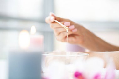 Kapalı kadınlar turuncu parafin kasesini tutarlar.