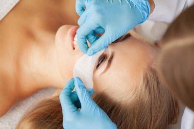 Kirpik uzatma işlemi, profesyonel bir stilist kadınların kirpiklerini uzatır.