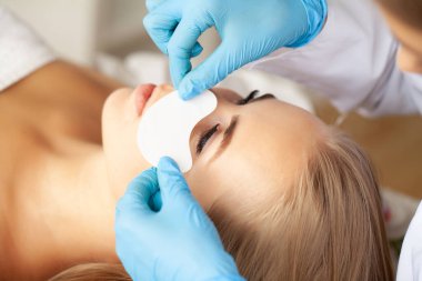 Kirpik uzatma işlemi, profesyonel bir stilist kadınların kirpiklerini uzatır.