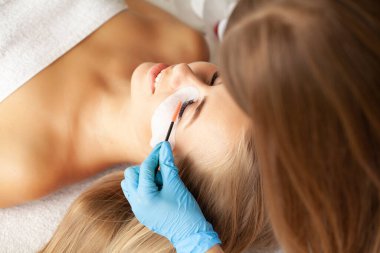 Kirpik uzatma işlemi, profesyonel bir stilist kadınların kirpiklerini uzatır.